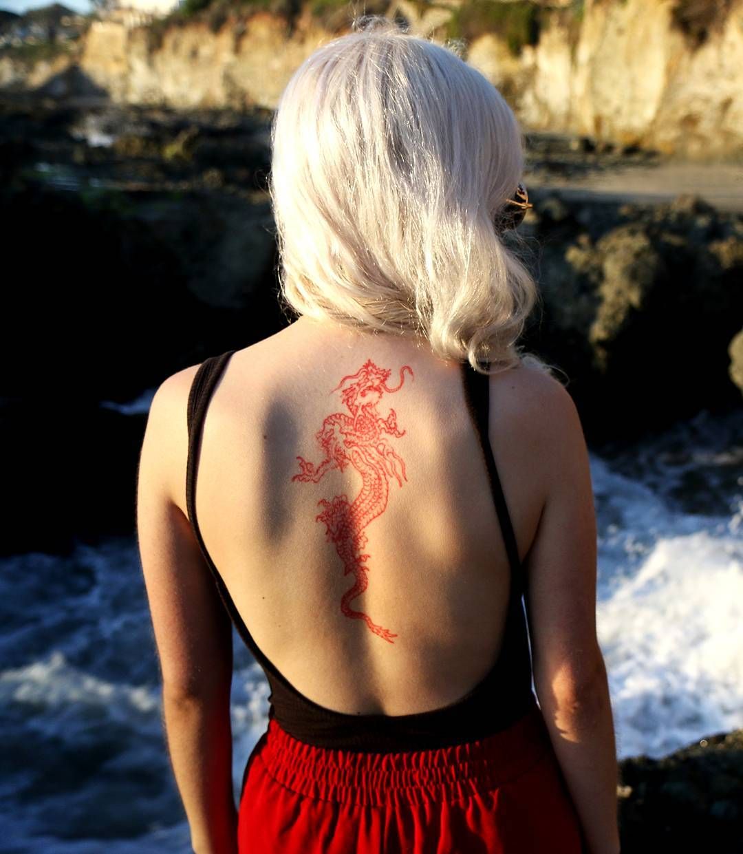 Red Ink Lotus Flower Tattoo On Girl Back Neck